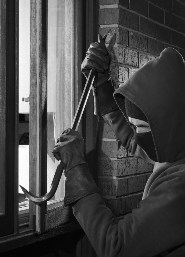 Burglar Using Crowbar To Break Into a House at night with room l